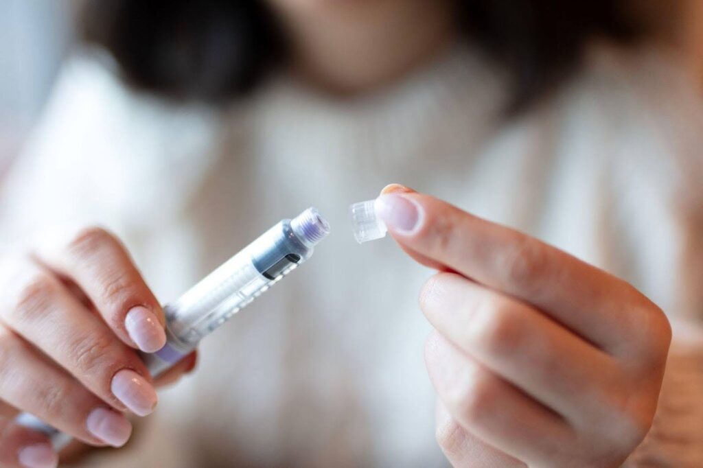 A woman examines a small piece of plastic in her hand, showing her focus and curiosity