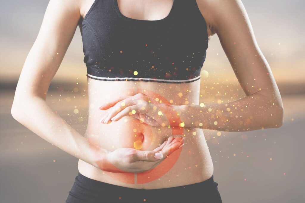 A woman holds her stomach with glowing red spots indicating abdominal pain