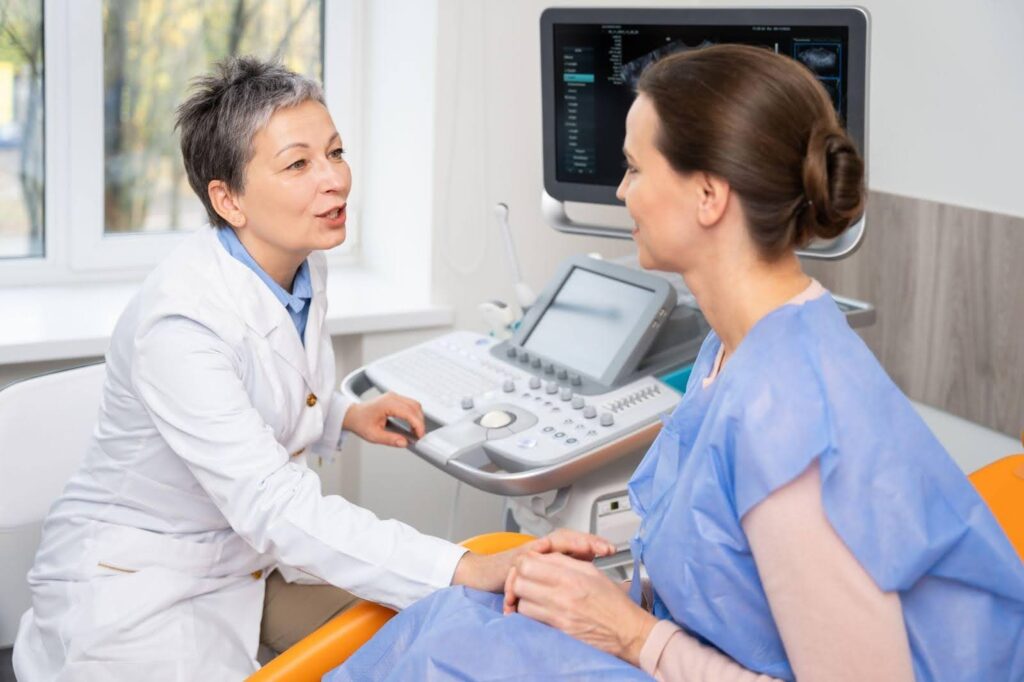 A woman discusses her medical concerns with a doctor in a hospital room