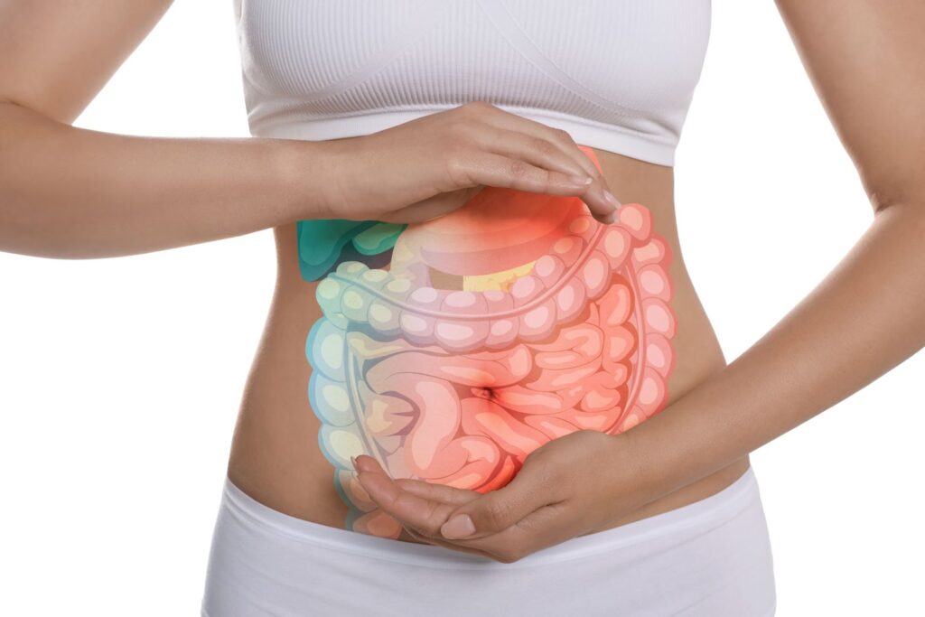 A person holding their abdomen with a colorful illustration of the digestive system overlay.