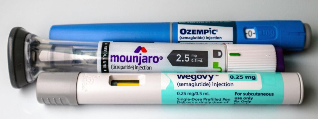 A collection of three inhalers and a thermometer displayed together on a neutral surface